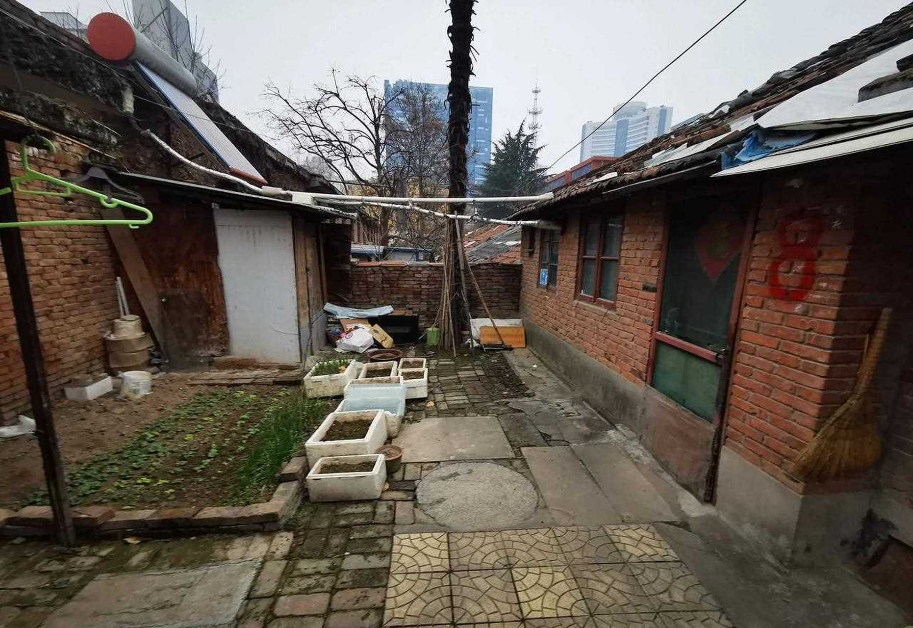 身在闹市区的竟有一处低矮平房,最矮的一排房子,户门高度只有一米八