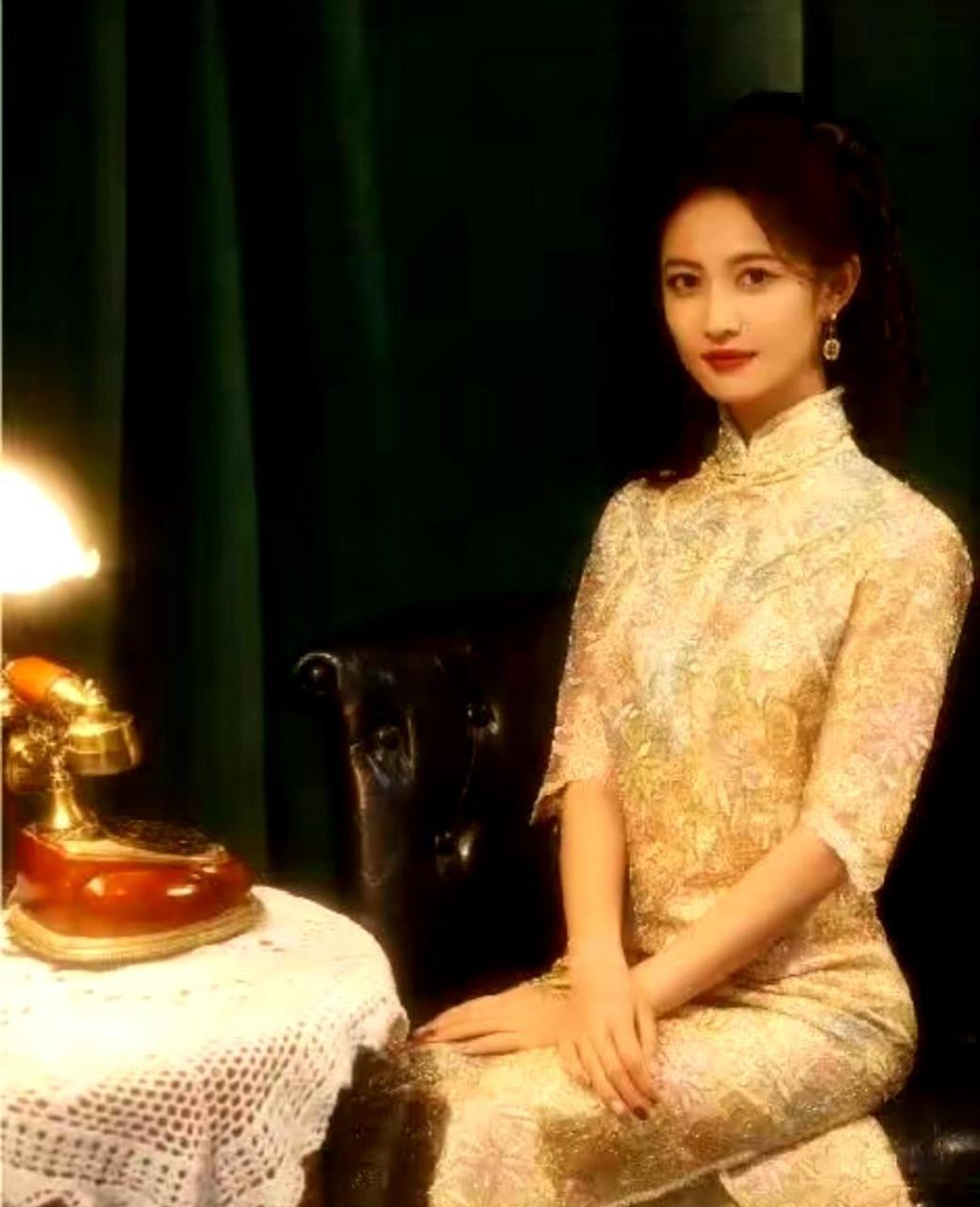 陈钰琪身着修身旗袍,在昏黄灯光下展现出坚毅与柔美的完美结合.