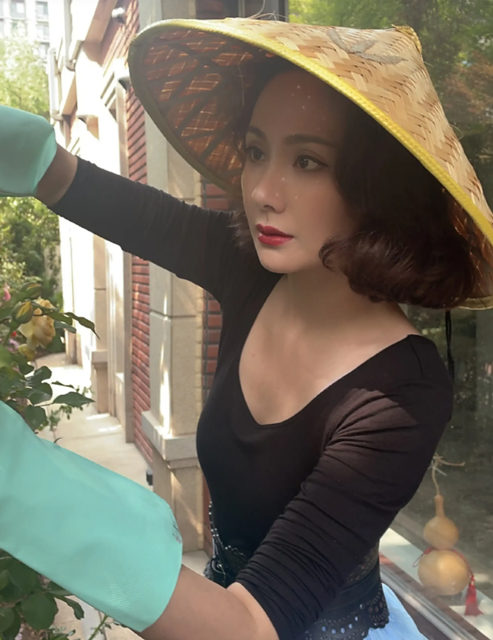 程莉莎真美. 大波浪卷发戴着草帽,黑衣蓝纱裙,配上大红唇