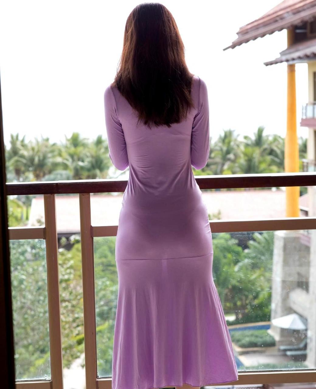 她身穿紫色裙子,背影优美动人.