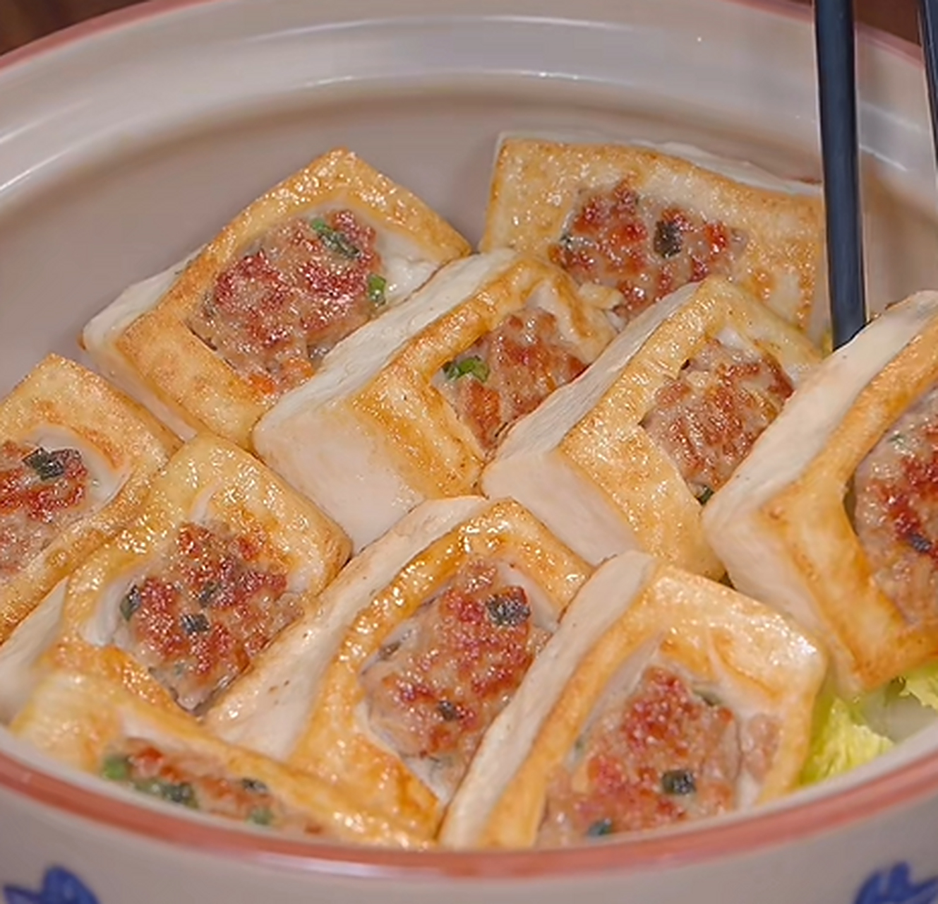 做法也很简单,首先嫩豆腐切成正方形,中间挖个小坑,挖出来的豆腐放入