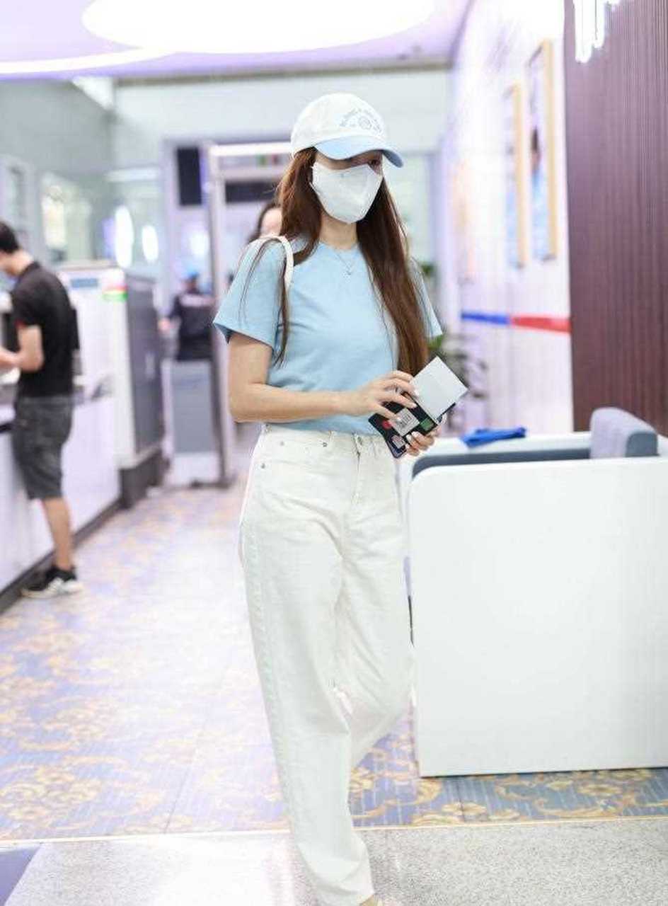 郑秀妍最新机场照,她戴一顶白色的棒球帽,穿一件浅蓝色的短袖短款t恤
