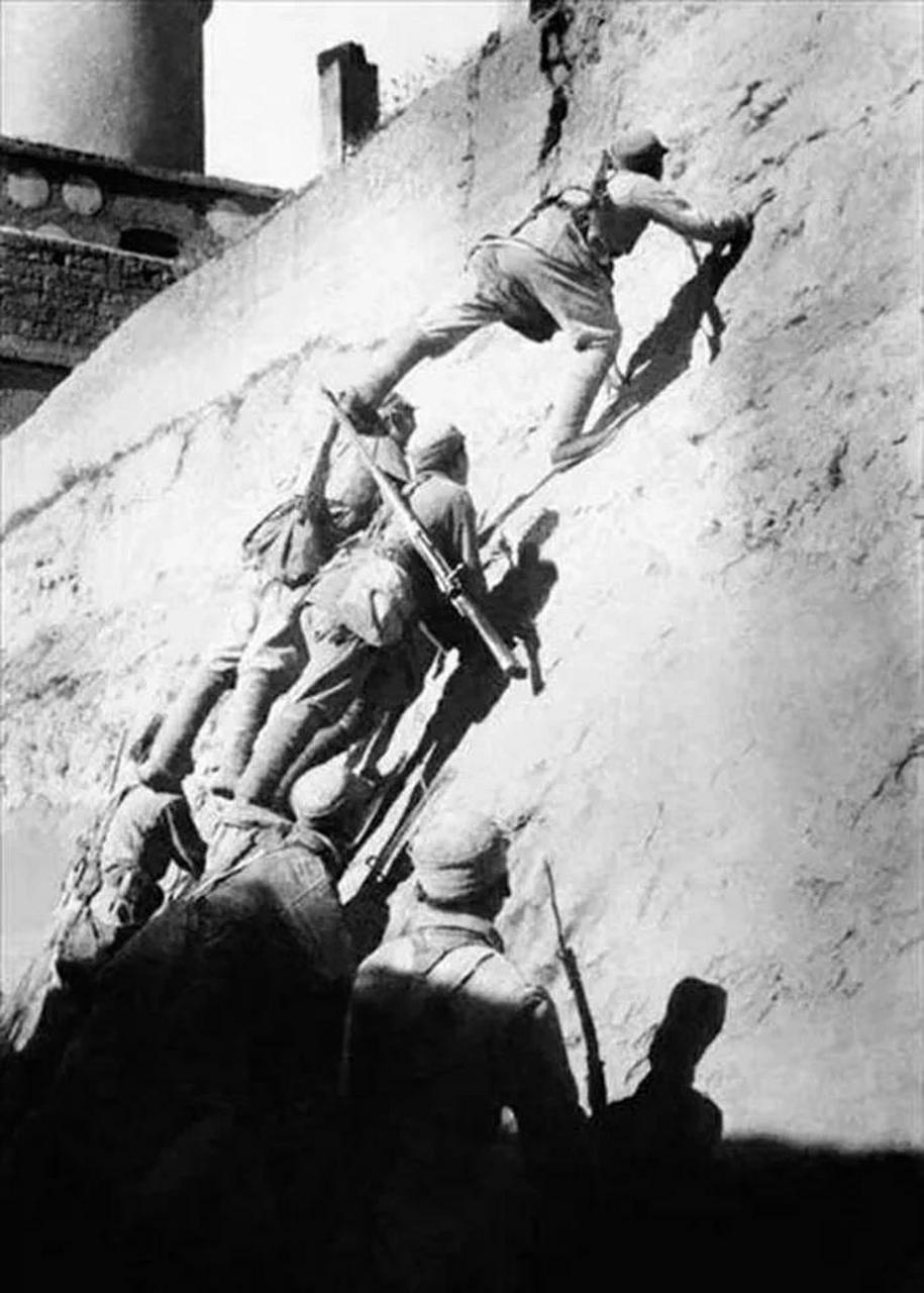 照片为:1947年5月4日,蟠龙战役中,解放军西北野战军独四旅战士搭人梯