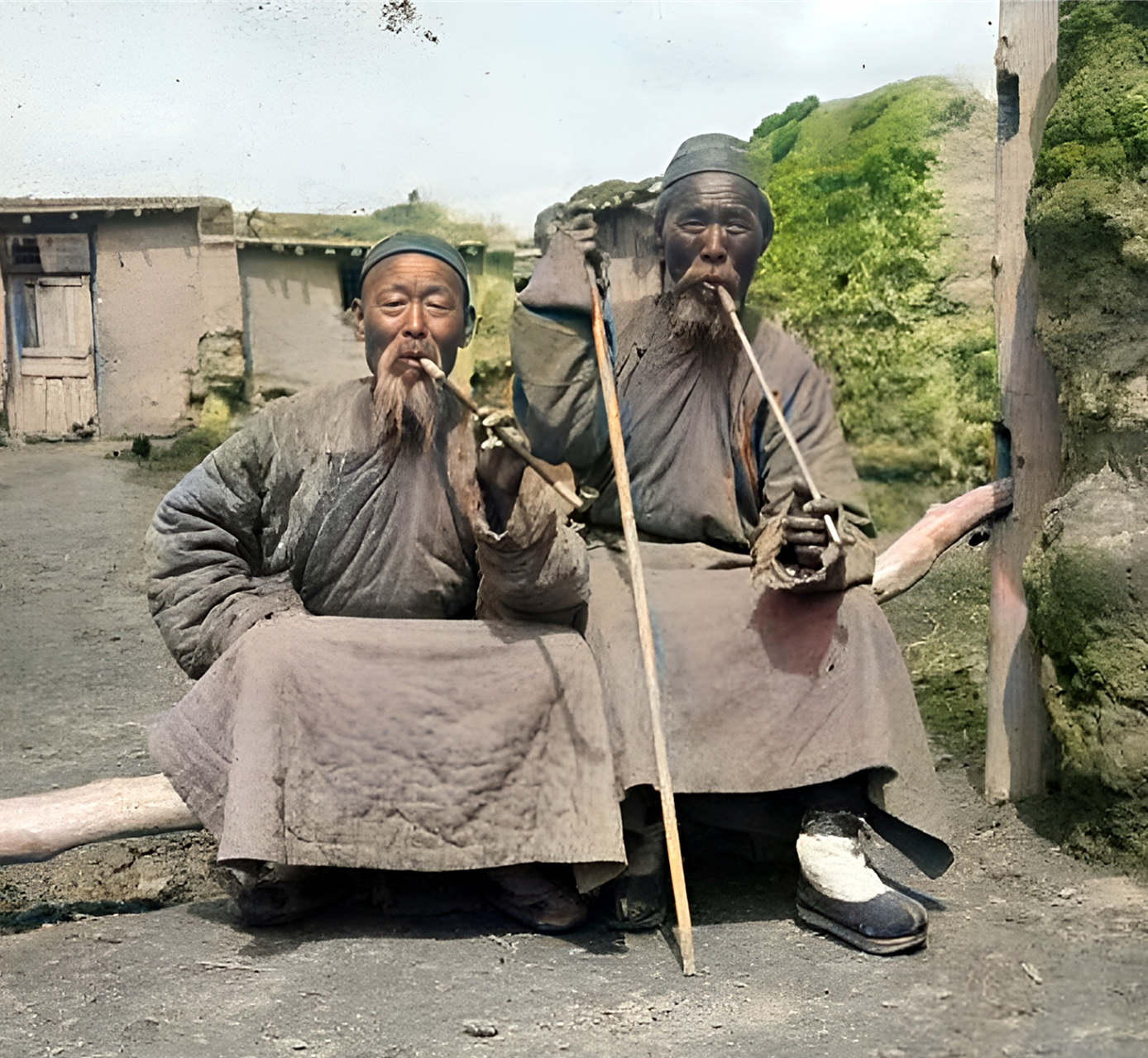 1906年,新疆两位满族老爷子坐在一起聊天吸烟.