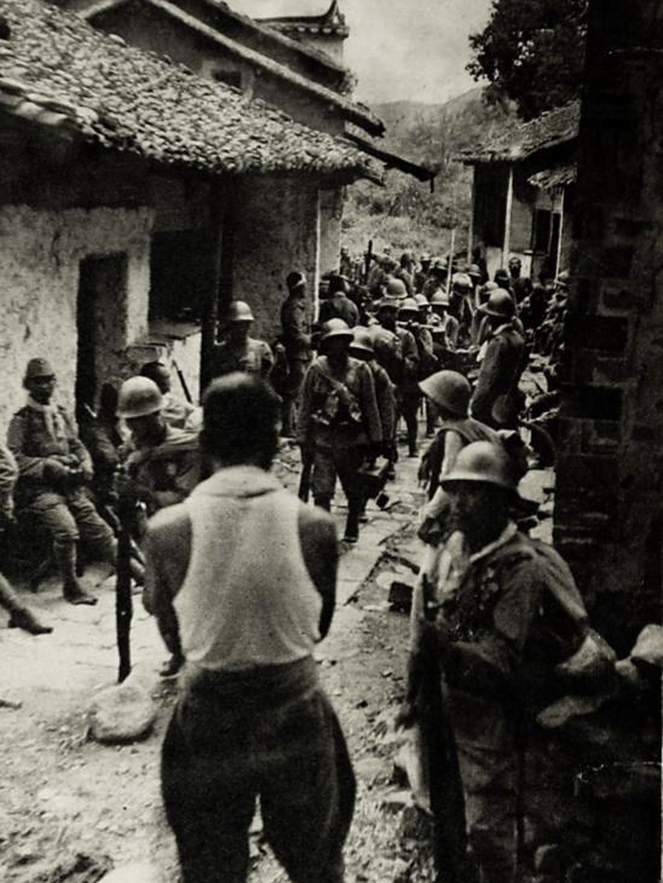 这是抗战时期日军在占领区扫荡的照片,镜头中,日军手持武器,将村里的