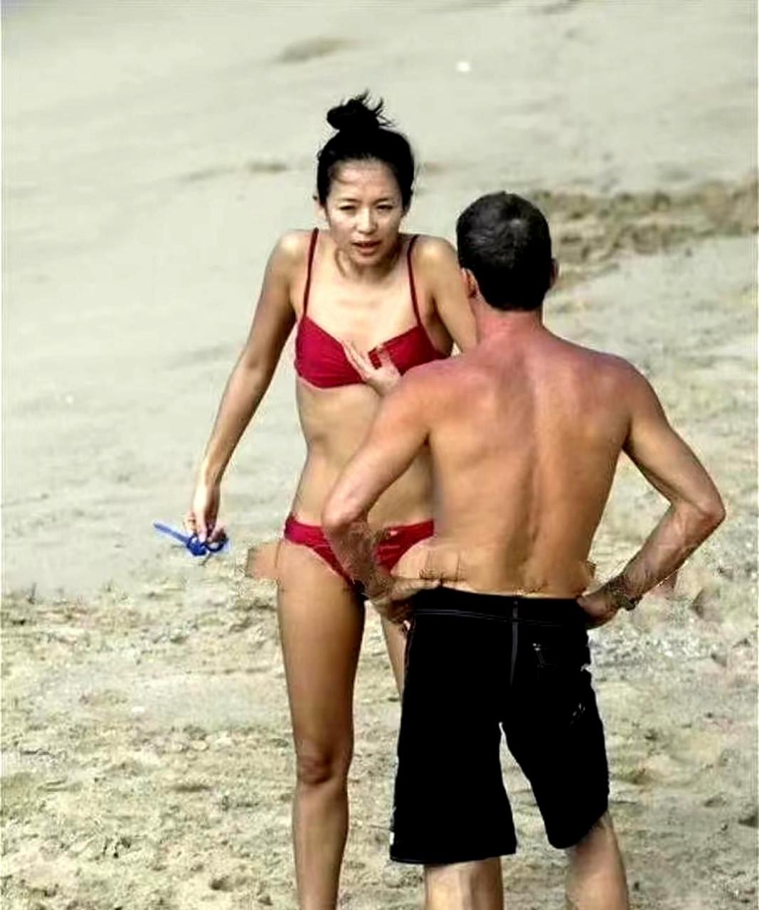 章子怡和她的外籍前男友在沙滩上玩耍,她瘦弱的身材和两人紧握的手指