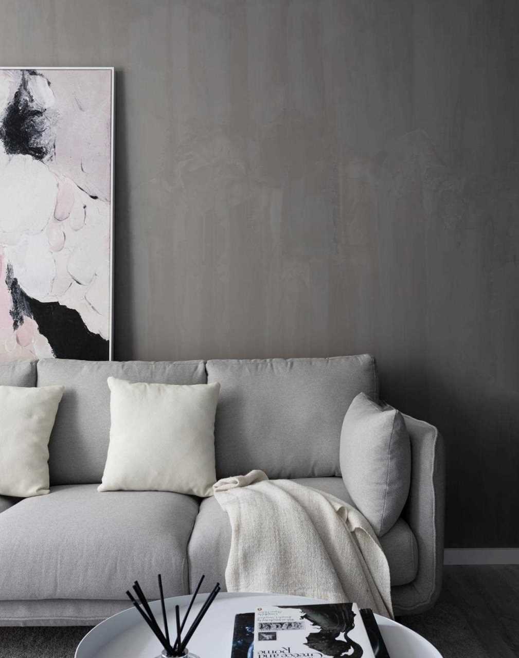 水泥灰的背景墙,三人位的布艺沙发,白色的抱枕,一大一小的黑白圆形