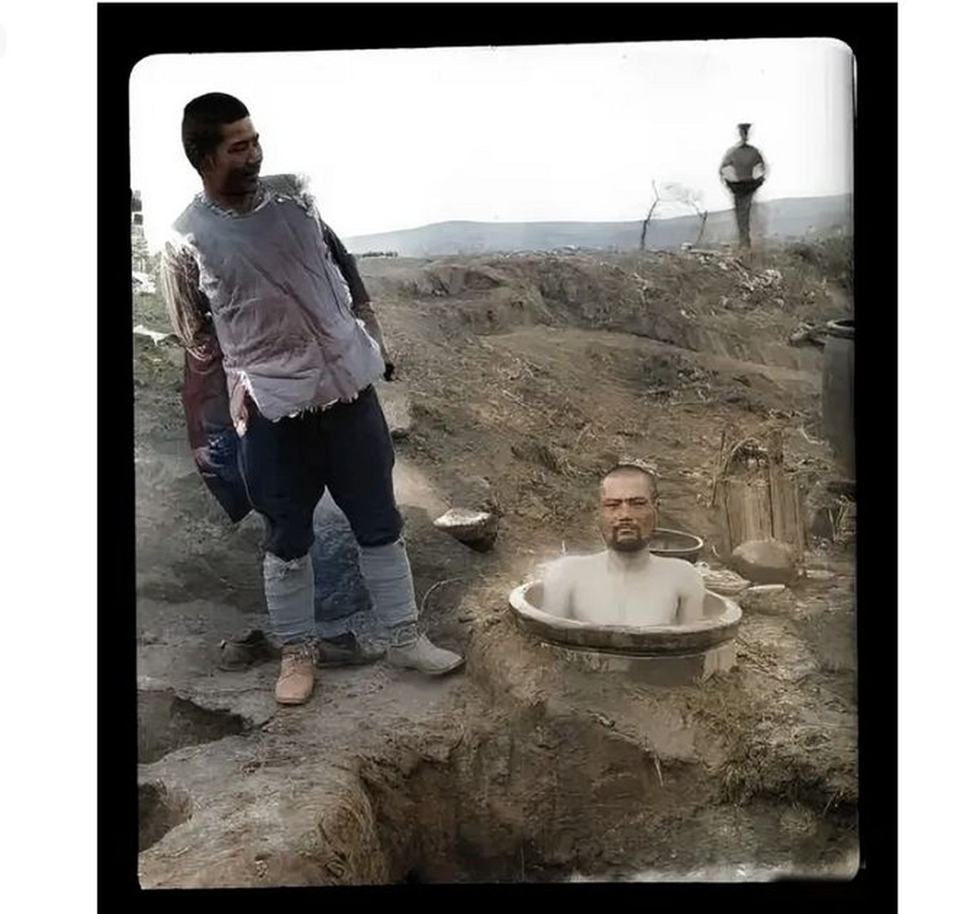 一个日本兵坐在大缸中洗澡,只见缸的一大半都埋在土里,但他却脱光衣服