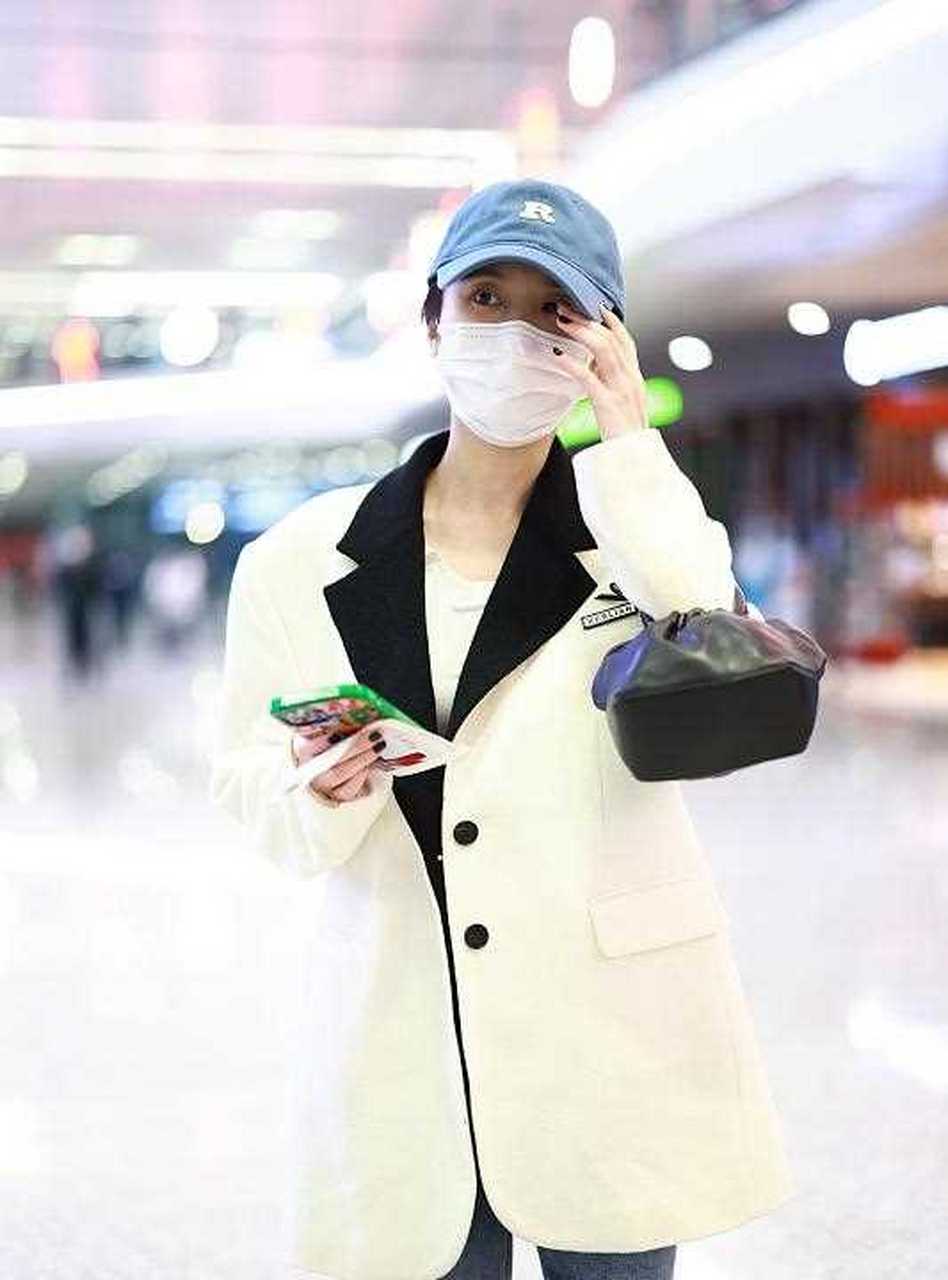 张慧雯最新机场照来了,她戴一顶蓝色棒球帽,穿一件白色的中长款毛呢