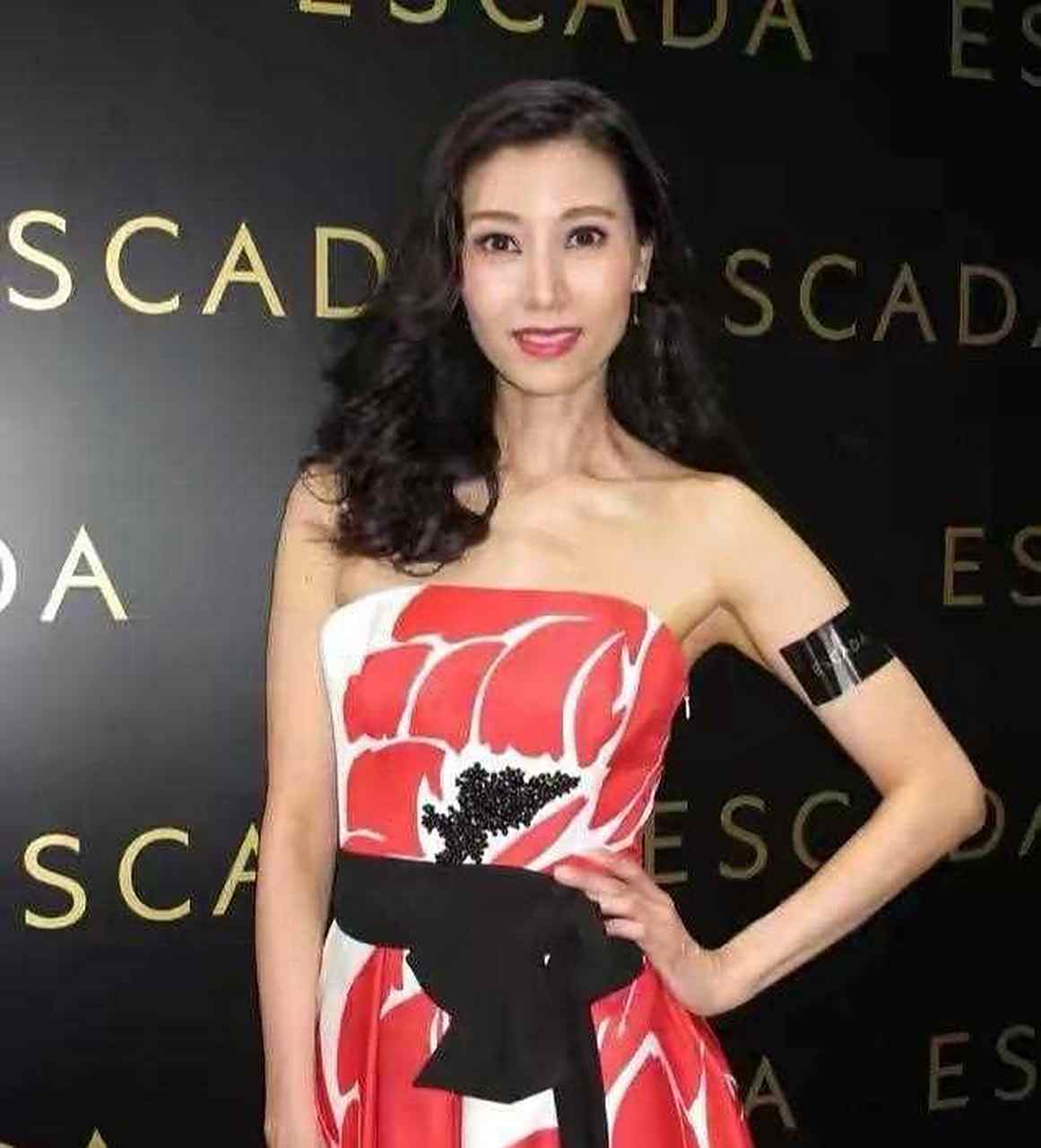 今年已经49岁的李嘉欣,身穿抹胸长裙出席活动,大秀身材白色的礼服加上