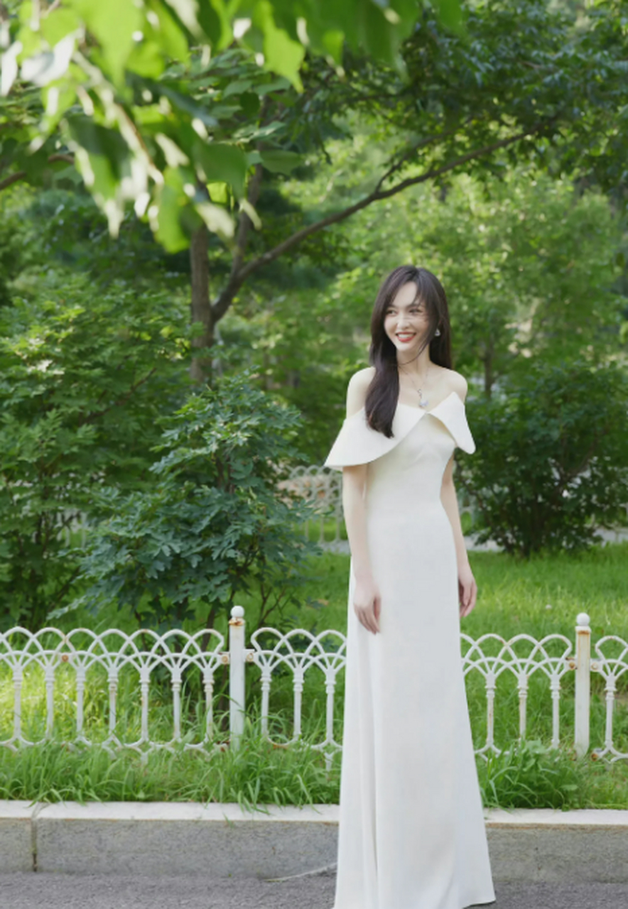 唐嫣一袭白色长裙礼服,抹胸露肩,在林荫小道上,满眼的新鲜绿色,太有