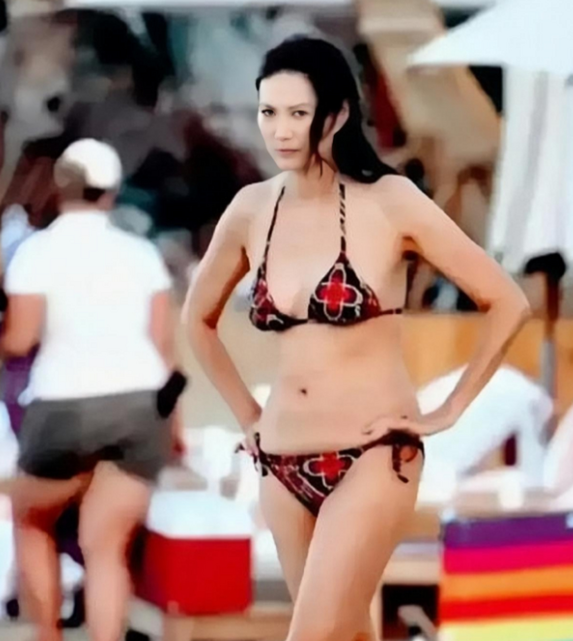 54岁的邓文迪在沙滩上游玩时的的几张泳装照,小腹平坦,没有一点赘肉