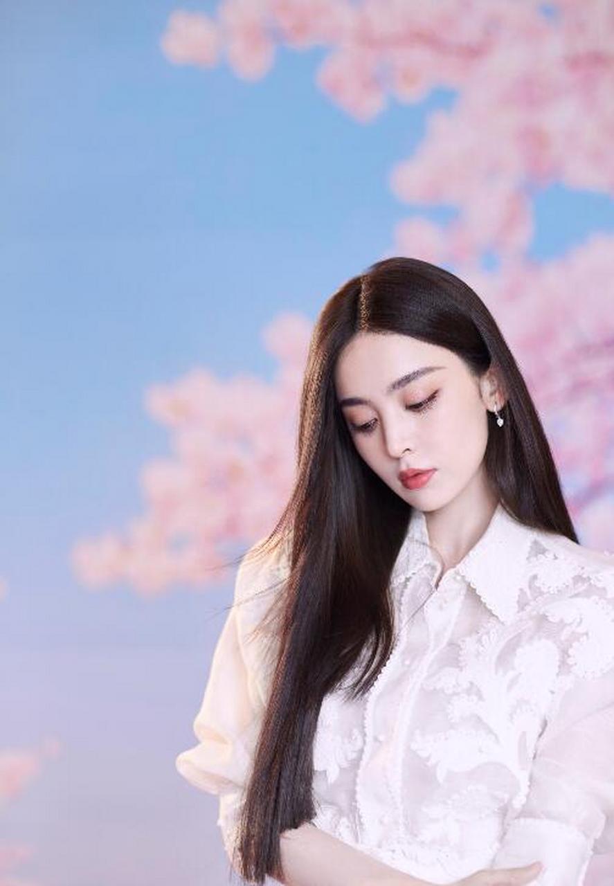 古力娜扎,镜头前或甜笑或双手捧脸卖萌,在樱花背景下美好治愈.