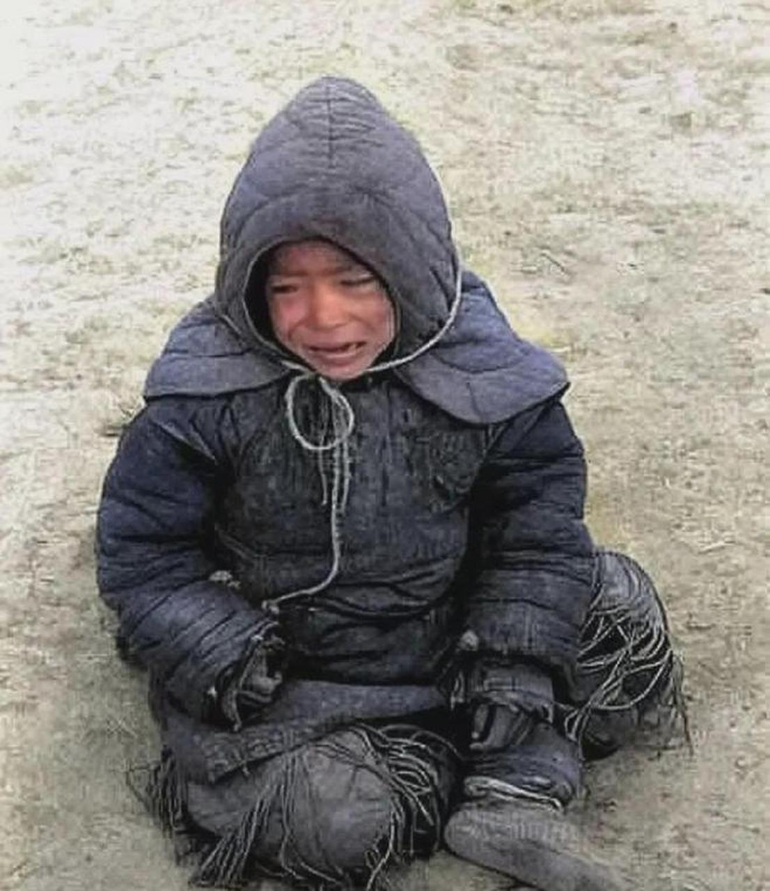 1942年,河南省,一名小男孩被他的父母遗弃在街头,他坐在地上哭泣,表情