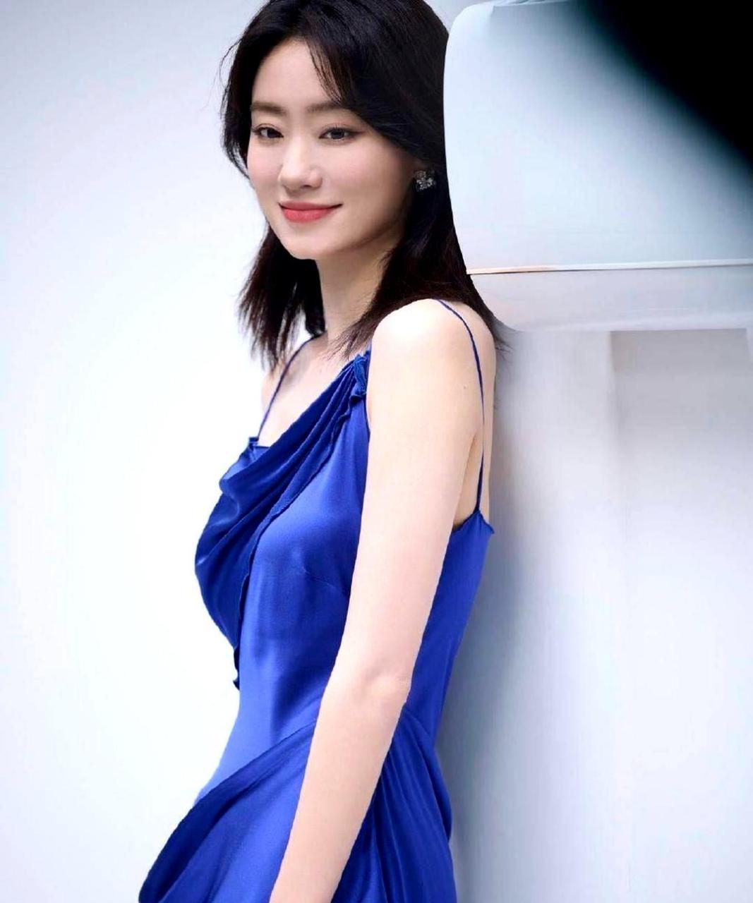 张小斐身穿蓝紫色吊带裙,优雅迷人,高开叉露出一双美腿.