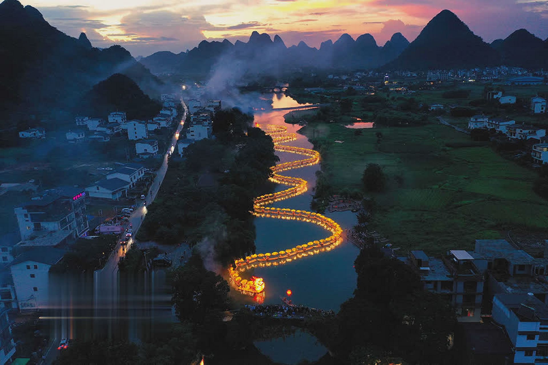 桂林市阳朔县遇龙河上,一条由55张竹筏组成的550米金色"巨龙"庆祝端午