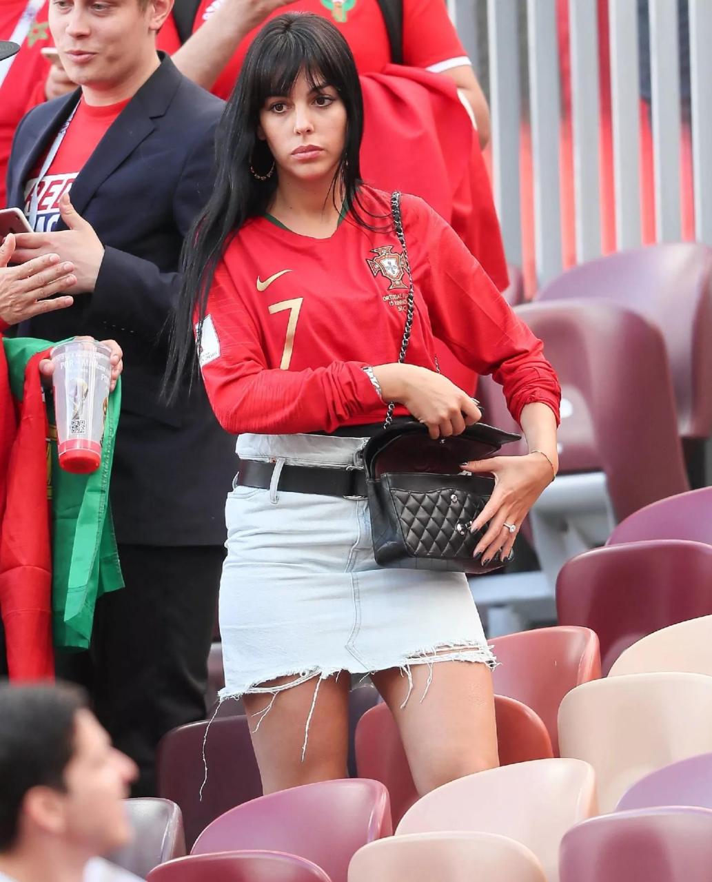 乔治娜亮相足球场馆为c罗加油助威,她穿着印有金色7号的红色t恤衫