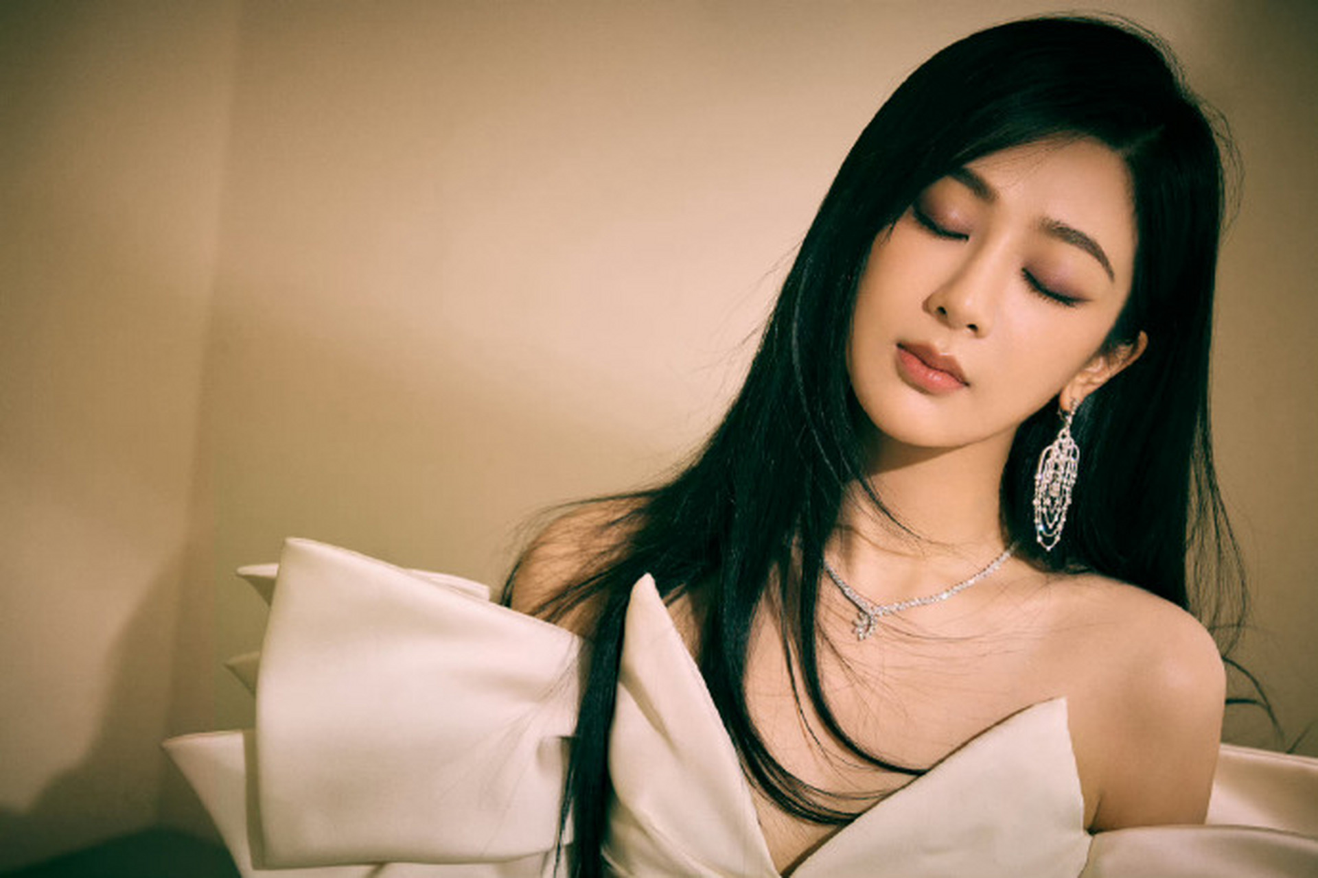 杨紫身穿一袭白色抹胸礼服搭配花瓣装饰的裙身,在黑色披肩长发与别致