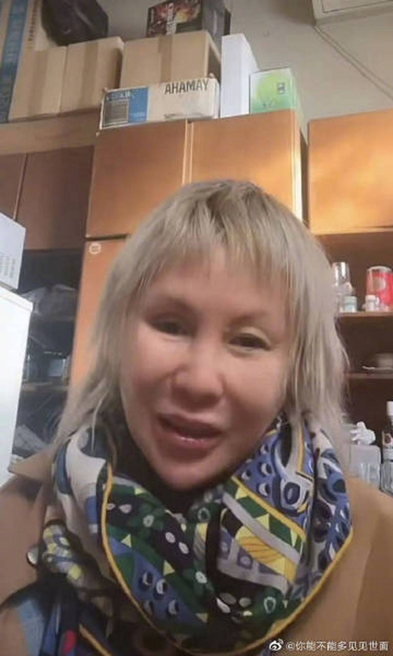 从视频中看,罗琦穿着卡其色的外套,脖子上围着花围巾,一头发凌乱的