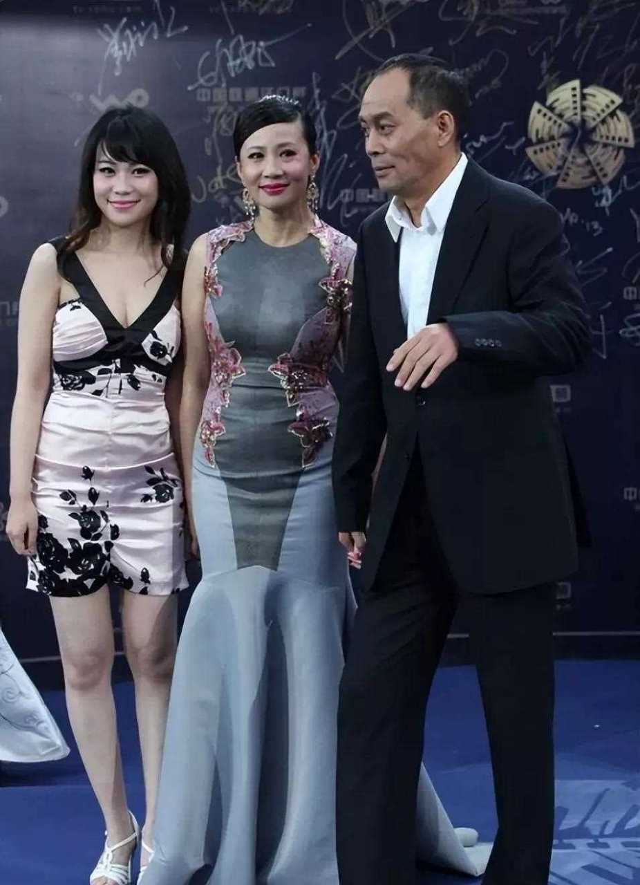 张光北携妻子陈炜还有女儿走红毯,陈炜身材丰膄,一袭灰色修身礼服裙