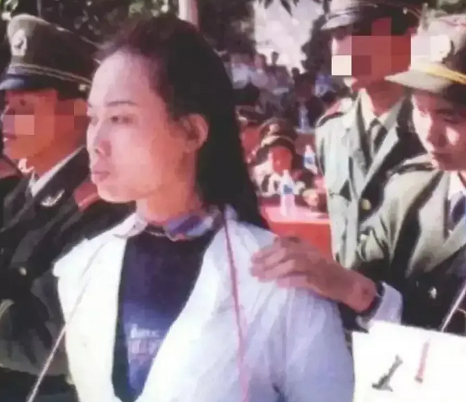 1995年,广东东莞,荣丰波被押往刑场准备执行枪决,镜头中荣丰波撅着嘴