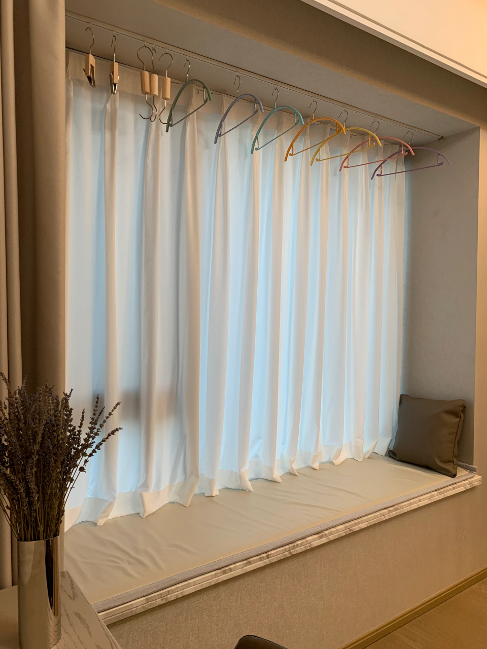 飘窗是内开窗,安装一根超薄窗帘轨道晾衣服不影响开窗,不晾衣服了推