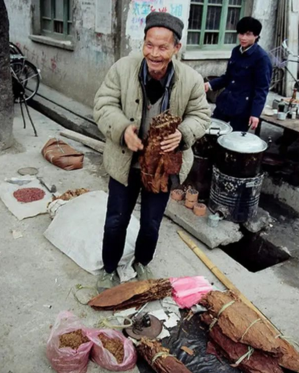 上世纪80年代,集市上卖旱烟的老汉.那时候很多人都抽旱烟,因为它便宜.