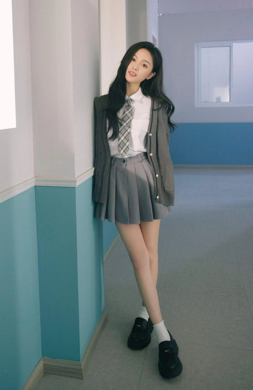 吴宣仪展现出了学院风的魅力,她身着白衬衫和百褶裙,充满了元气十足的