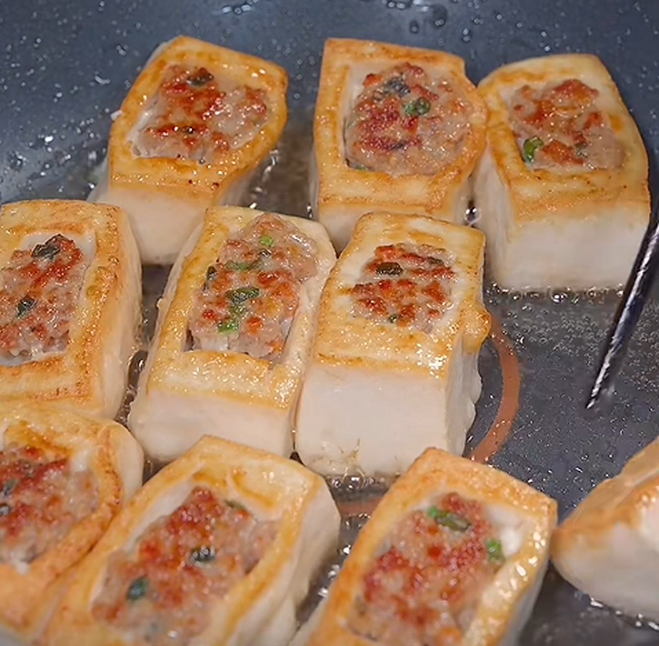 做法也很简单,首先嫩豆腐切成正方形,中间挖个小坑,挖出来的豆腐放入