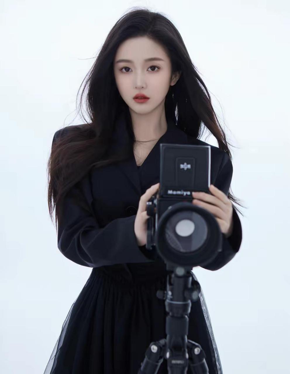 在写真中,我们看到曹婉瑾穿着黑色短裙,脚穿黑色长靴,露出修长的美腿.