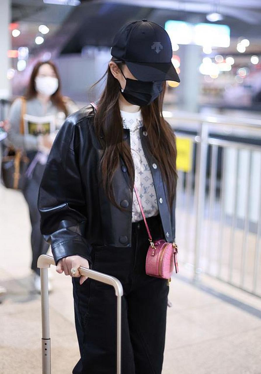刘亦菲街拍,她穿了一件黑色的短款皮衣,内搭一件白色半高领的胸前印花
