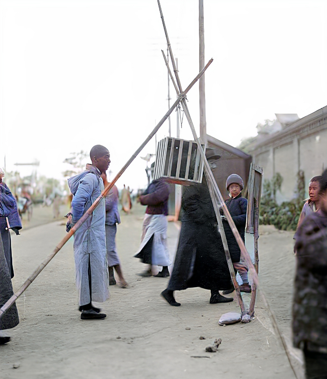 1914年,一名罪犯被枭首示众,他的头颅被装在一个木笼里,用三根竹竿支