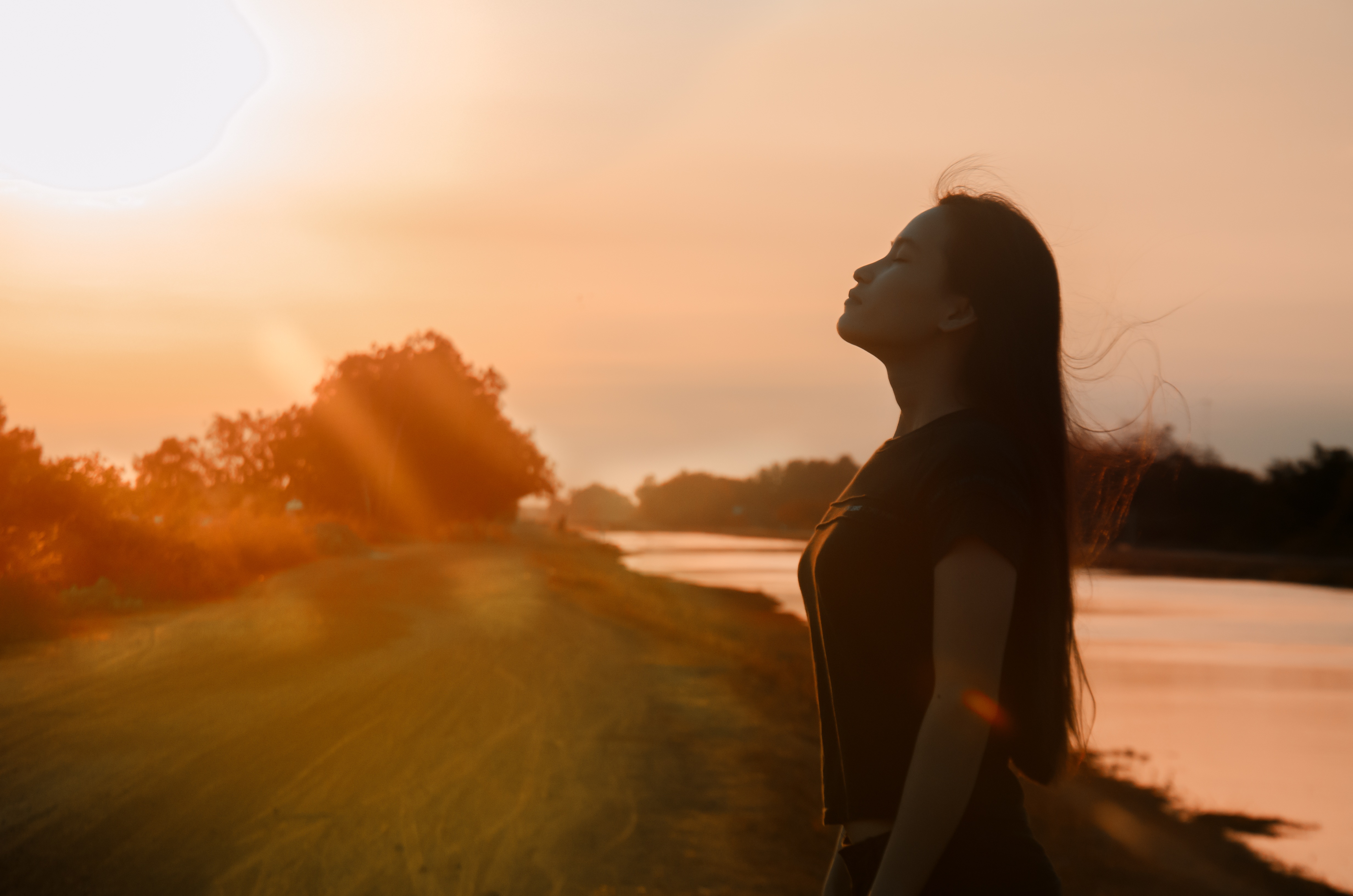 夕阳下,一个美丽的女子站在那里,让人不由得有一种享受自然的感觉,她