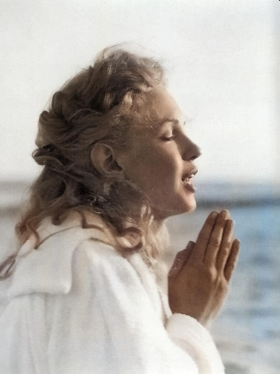 双手合十认真祈祷的玛丽莲梦露,此时的她闭着眼睛,专注的祈祷着,没有