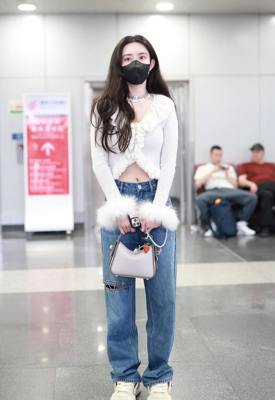 孟子义机场街拍,白色荷叶边针织衫搭配阔腿牛仔裤,白色运动鞋时髦复古