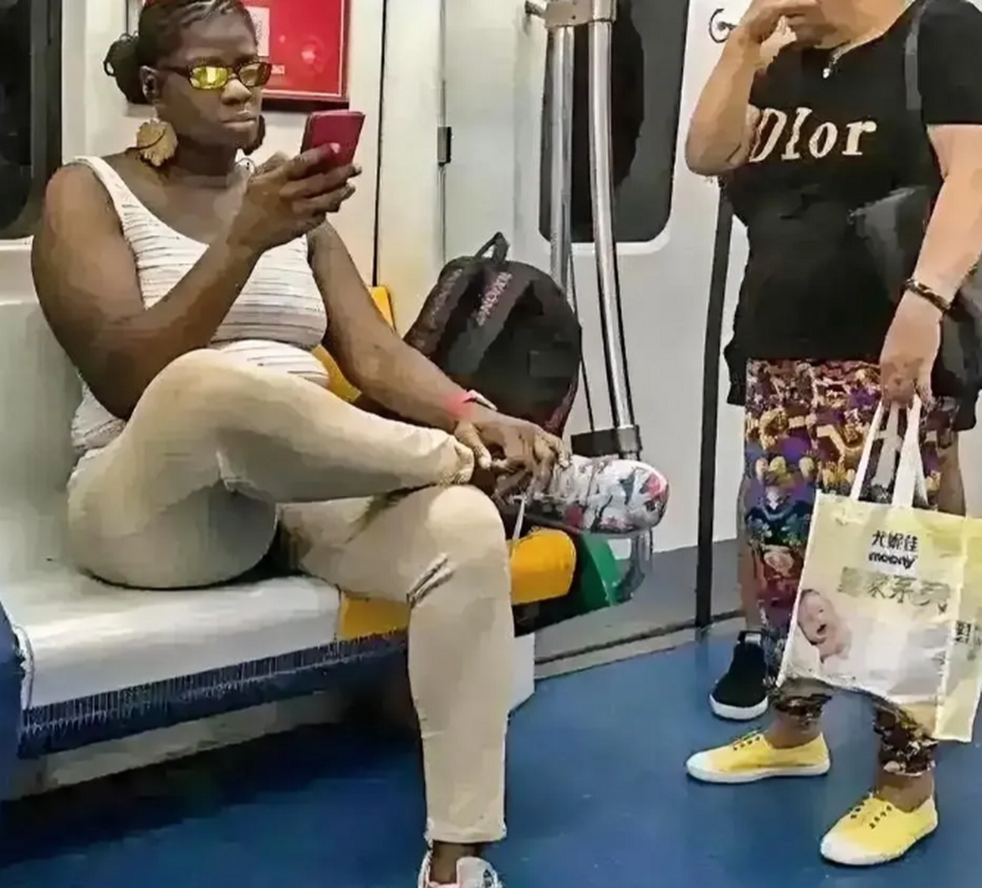 广州地铁一非洲黑人女子一人拿着东西共占了三个座位.