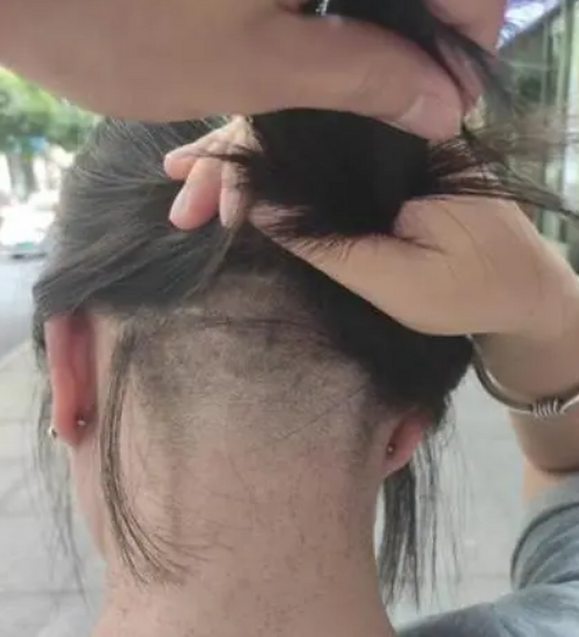 女子后脑勺头发被理发师剃掉一半.