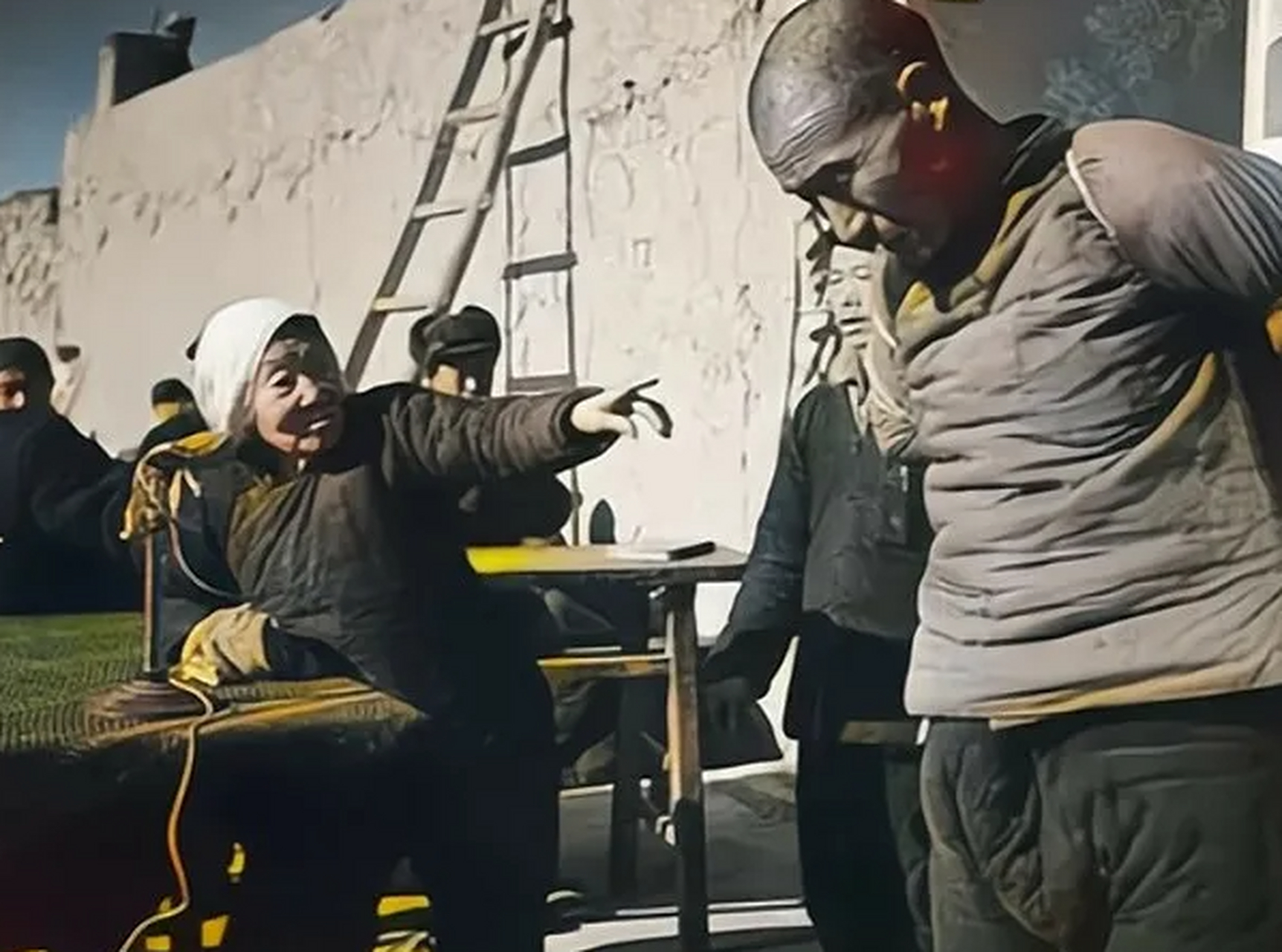 50年代初斗地主时的一张照片,一名刚翻身不久的老大娘手指着挨斗的