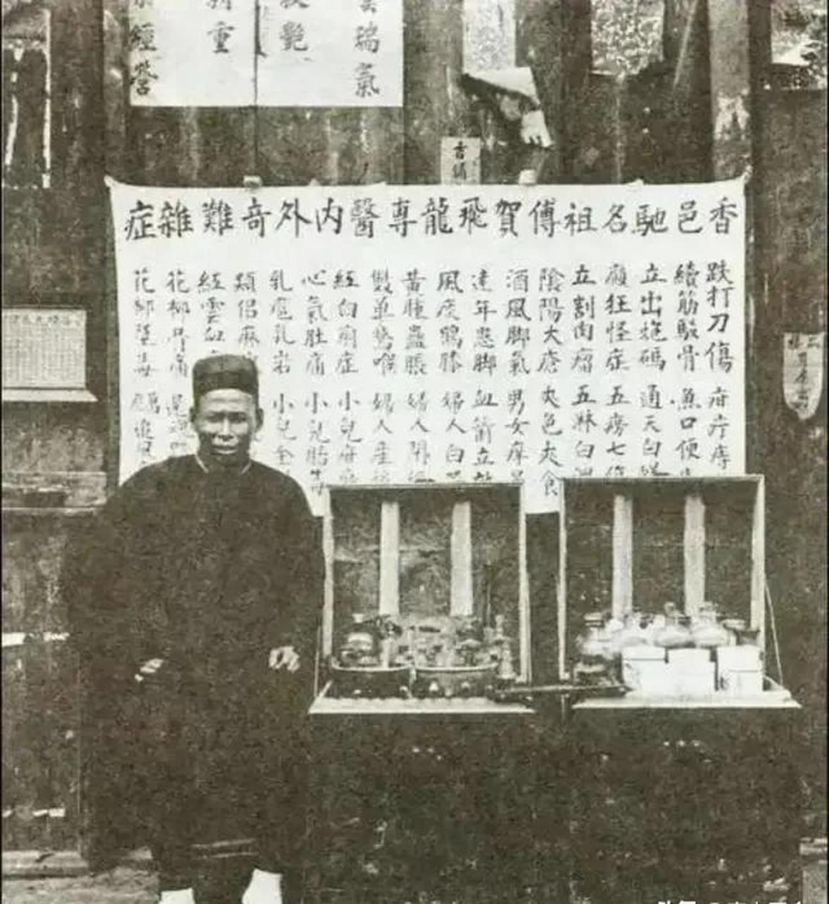 照片拍摄于清末时期,具体地点不详,一名江湖郎中坐在自己的摊位之前
