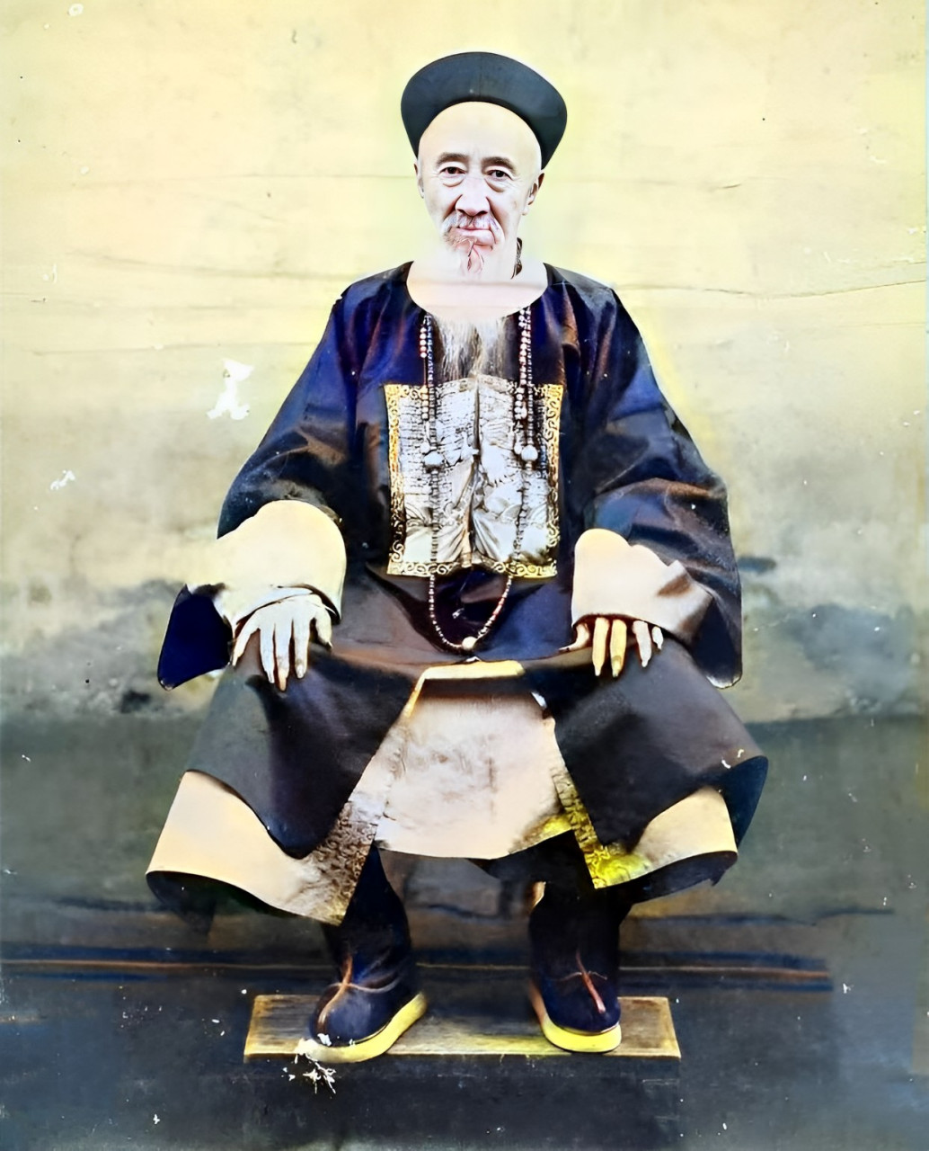 晚清时,头戴山官帽上的一位白胡子官员,身穿常服大衣,脚穿朝珠,脚蹬官