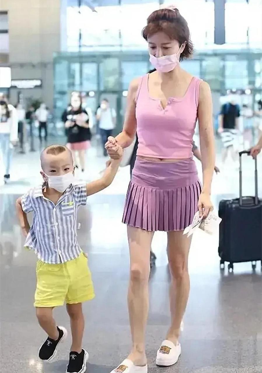 gif创作人# 46岁金巧巧穿"泳衣"走机场,露脐装大秀马甲线,小短裙一双