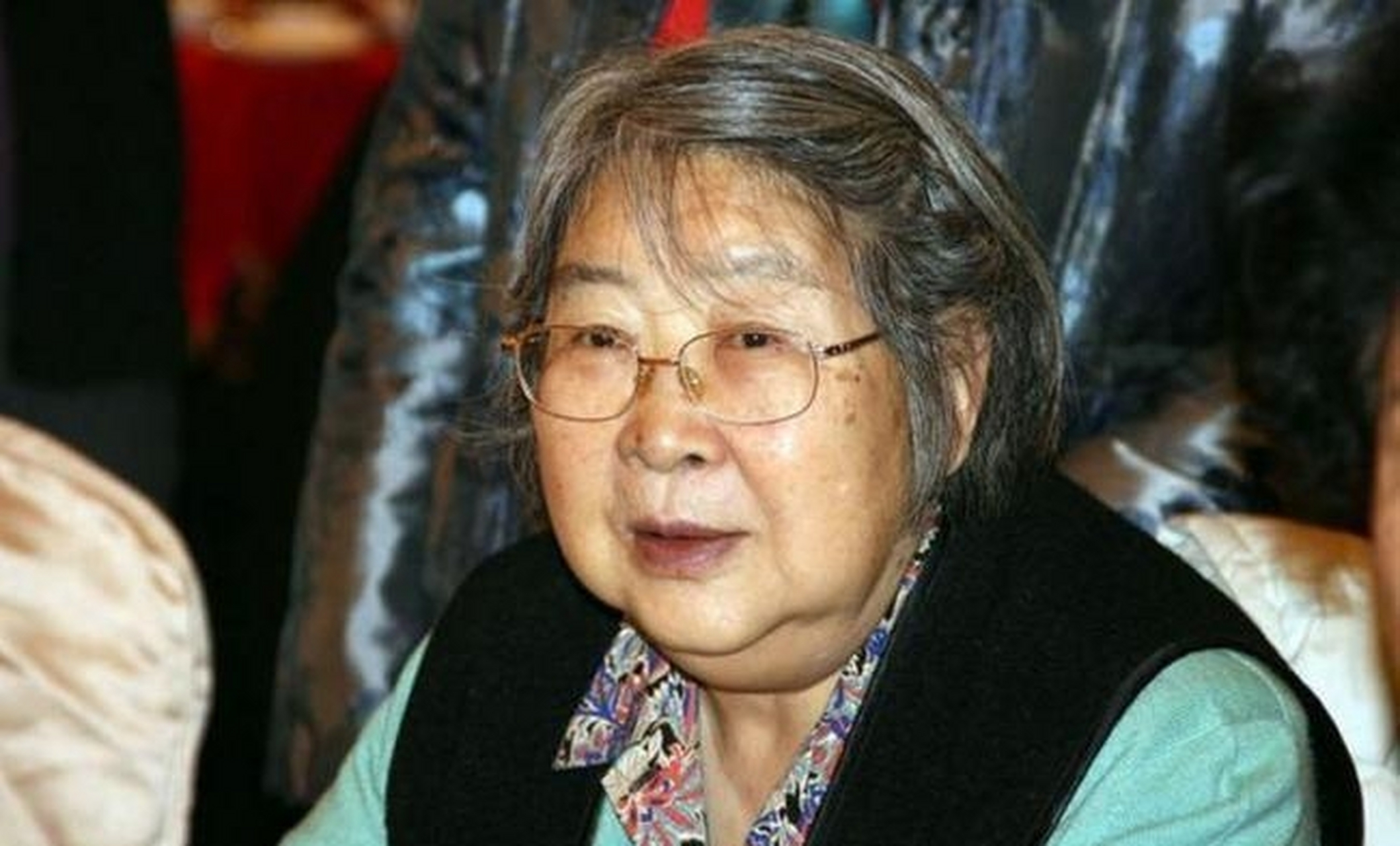 这张照片展现了李敏晚年的生活状态,她已经年迈,身体状况不佳,需要坐