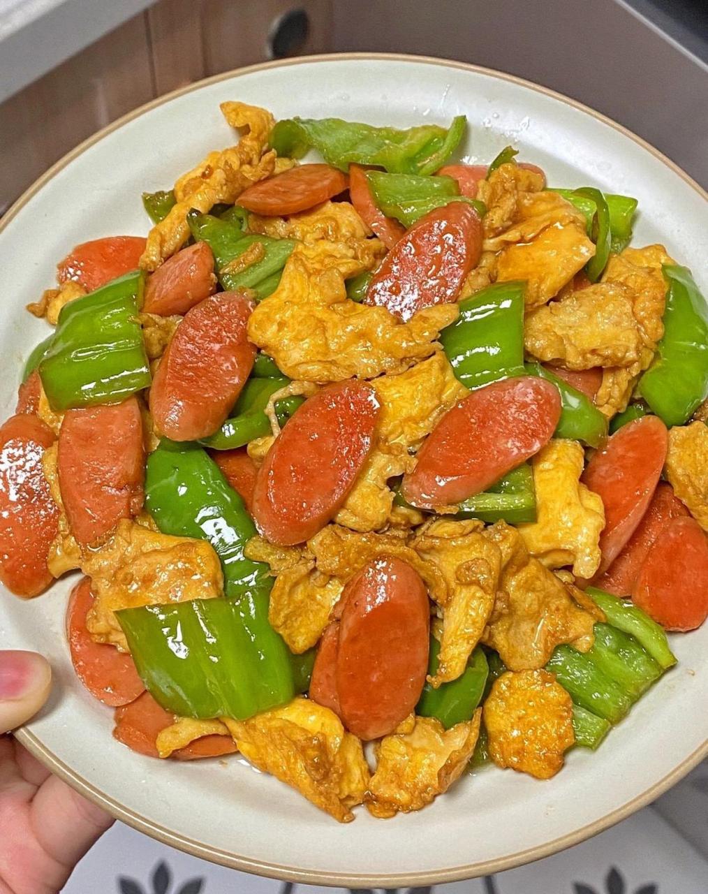 肠,两个鸡蛋 -做法: 热锅倒油放入鸡蛋炒熟盛出 倒入青椒火腿肠炒一炒