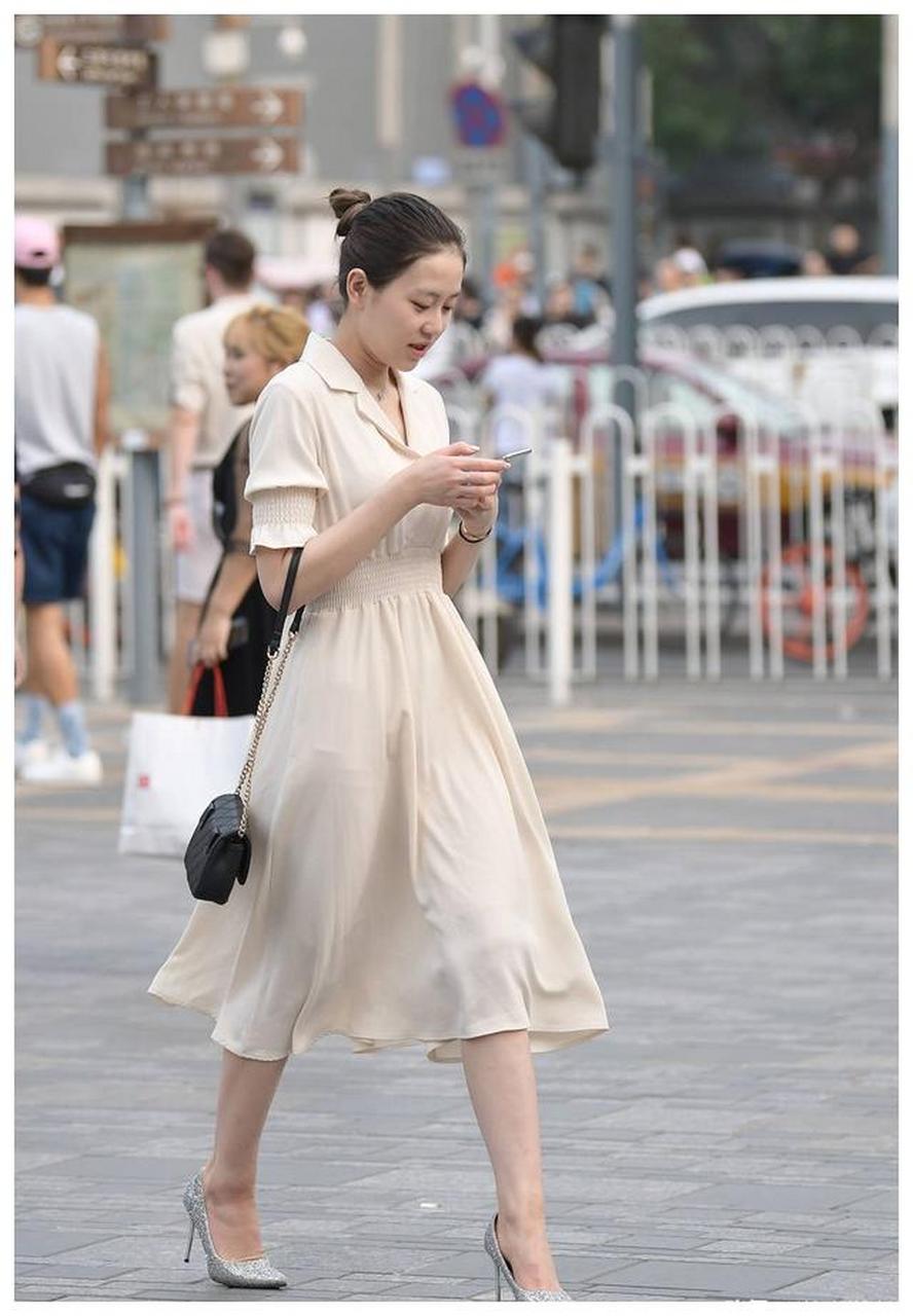 米色连衣长裙,过膝的裙摆,搭配尖头细跟鞋,衬托身材