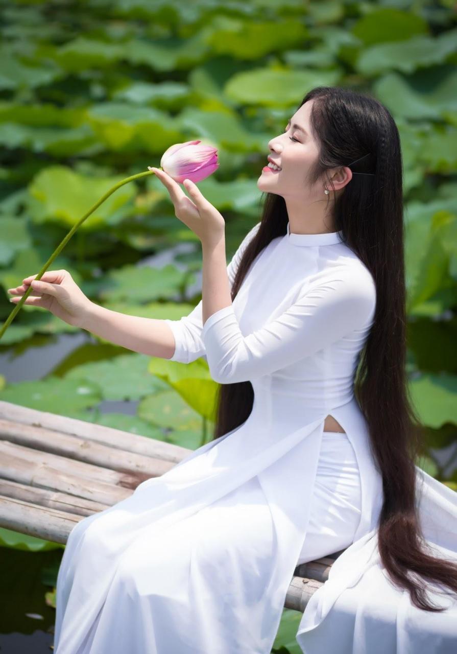 穿着纯白色的奥黛,在荷塘里拍写真,画面清新又唯美