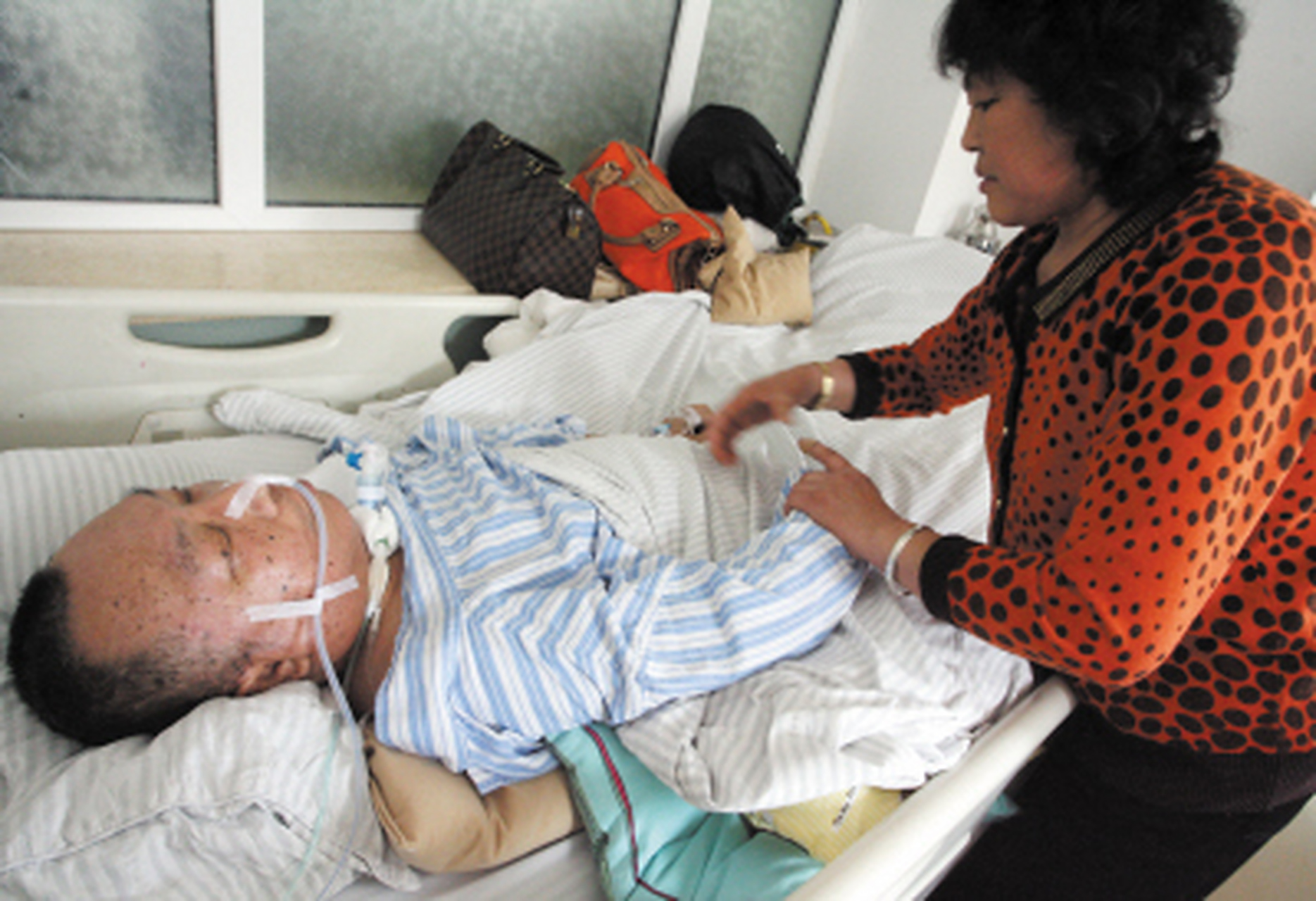 一个70岁的老人躺在医院病床上,被他们的子女包围着.