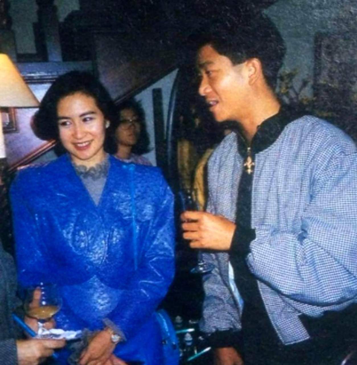 何超琼和好友陈百强合影,她穿着蓝色礼服,显得非常亮眼.