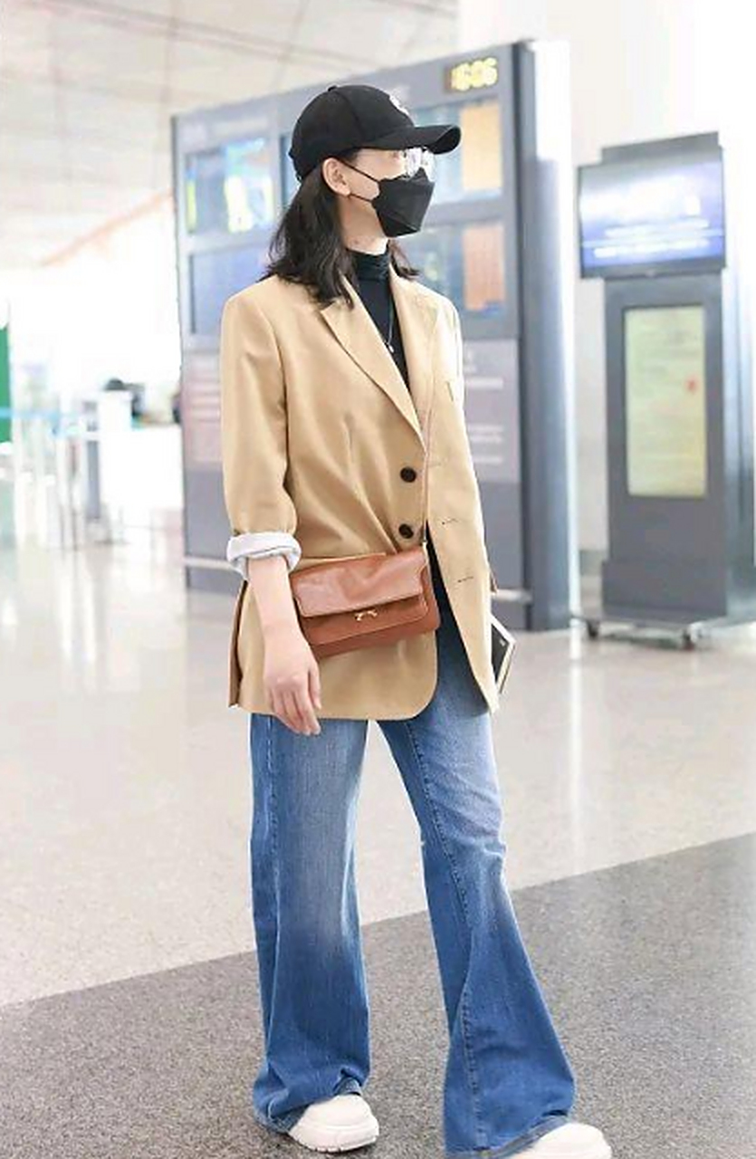 陈数街拍,她穿了一件浅卡其色的休闲风西装,内搭黑色的半高领t恤,搭配