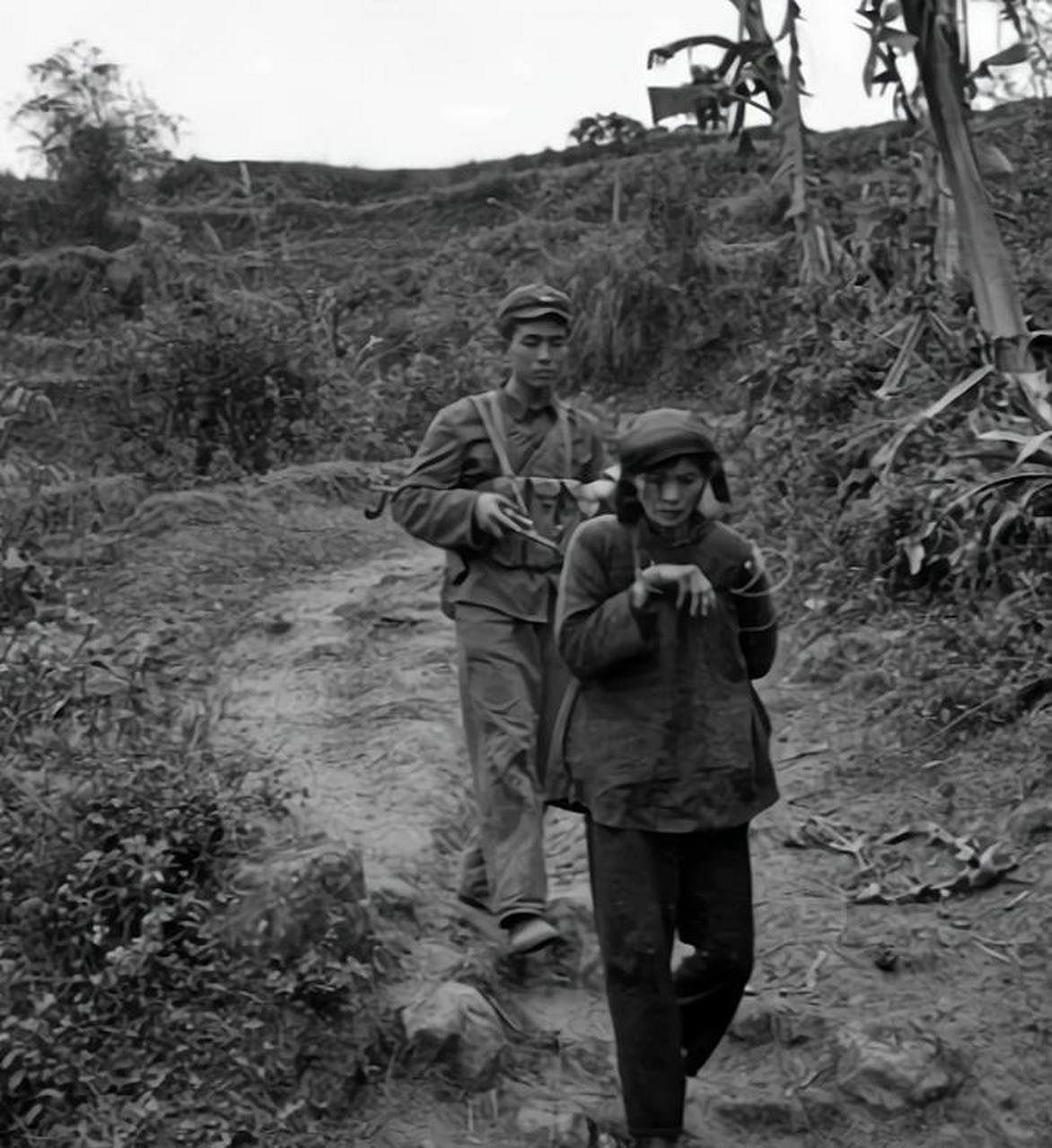 1979年,谅山战役中,一名被俘的越南女兵,正被我军战士押送!