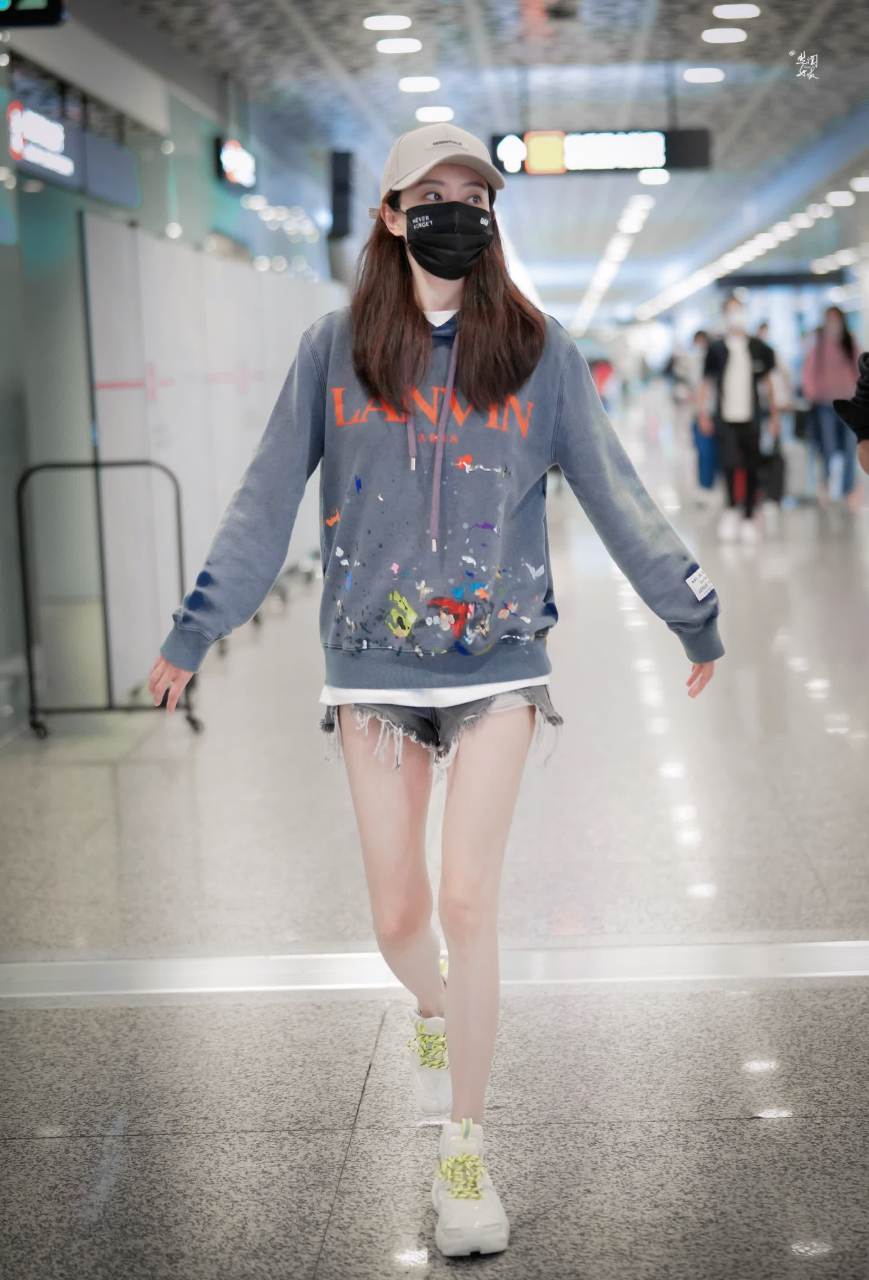 张小斐机场私服更新了,老式泼墨连帽卫衣搭配毛边牛仔短裤,脚上荧光绿